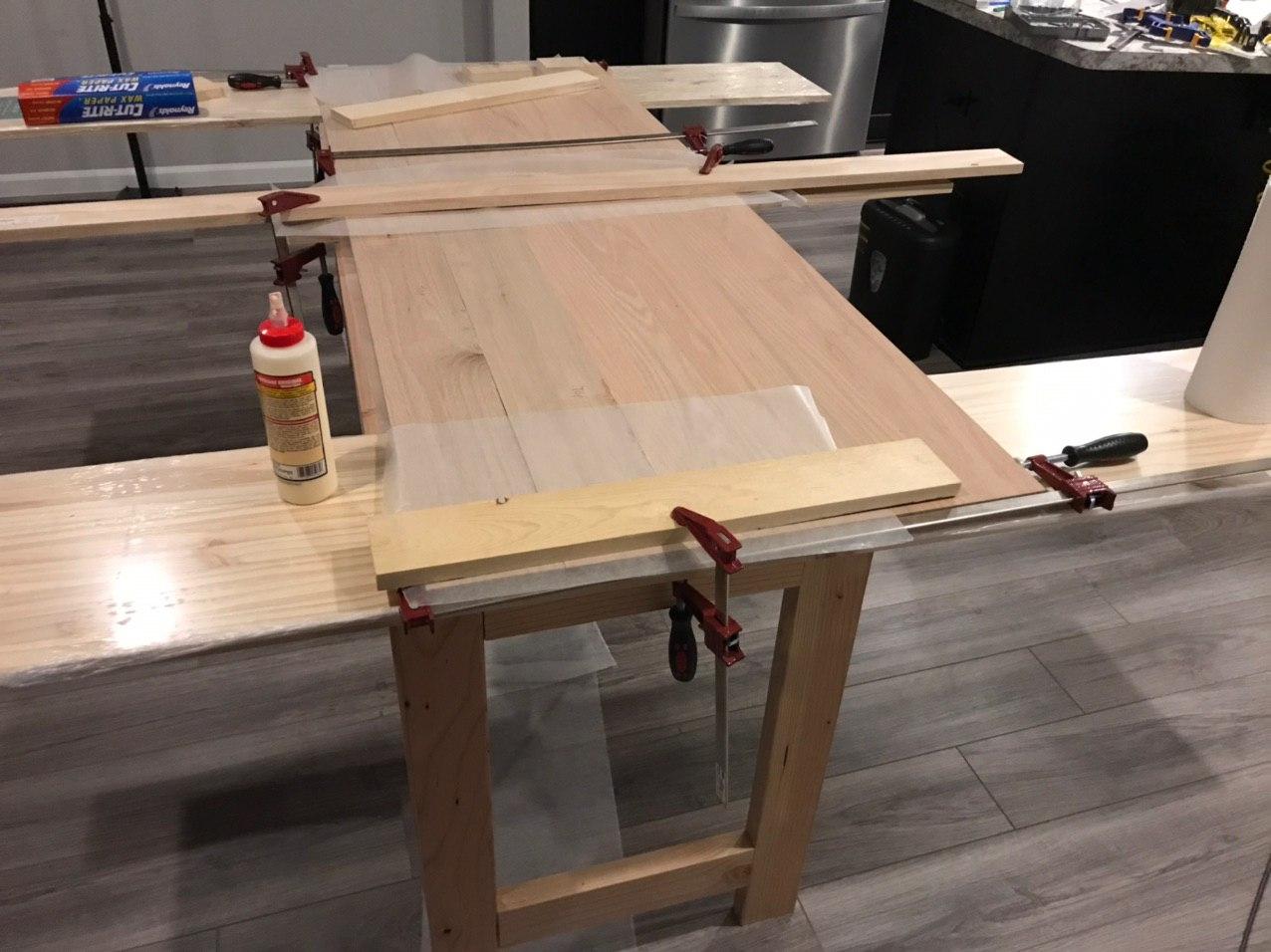 Clamps and wood glue to join planks of wood