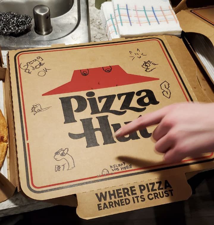 a pizza box with the sticker 'bet' doodled on it